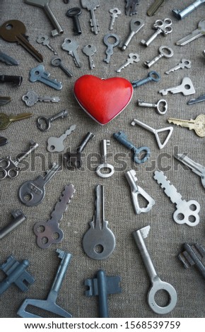 keys strive to the red heart, vertical conceptual photo, shot at an angle