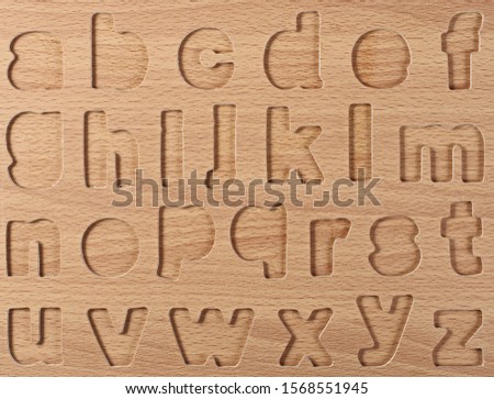 Wooden imprinted alphabet on wooden background