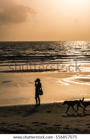 Silhouettes of photographers who shoot the sea during sunset. Goa, India.