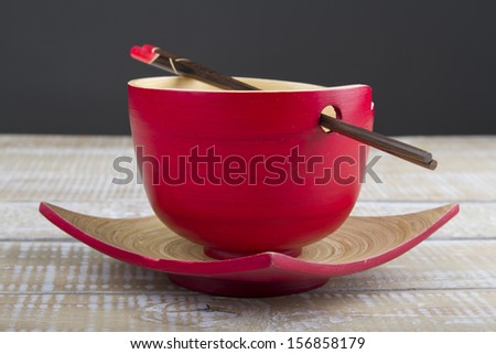 Bamboo plate and bowl with chopsticks on wood