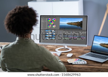 Young Male Editor Editing Video On Computer At Workplace