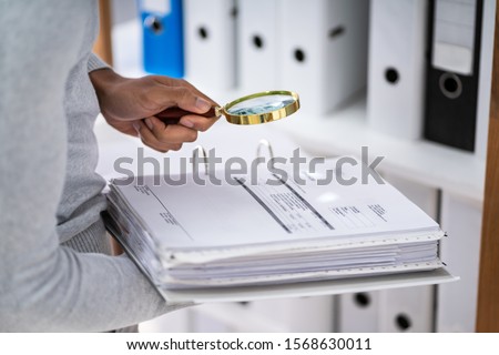 Close-up Of Auditor Inspecting Financial Documents 