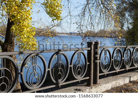 Black fence near the water, park, autumn