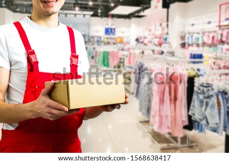 mage of a happy young delivery man in red delivery clothes