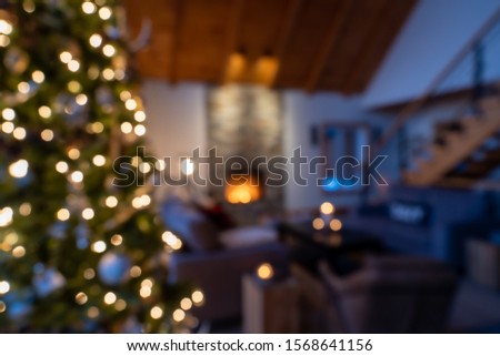 Defocused Christmas decor in a living room with a fireplace in background.