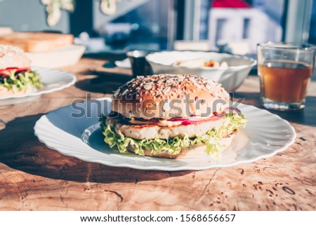 Chicken burgers on wooden slab table on food cort. Sunny day. Street food. Selective focus. Fastfood concept