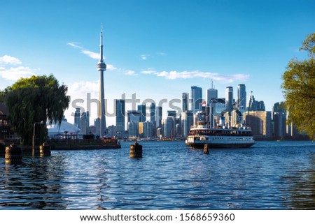 Toronto, Ontario, Canada, view of iconic Toronto skyline showing ferry boat arriving at Centre Island by day in fall season.