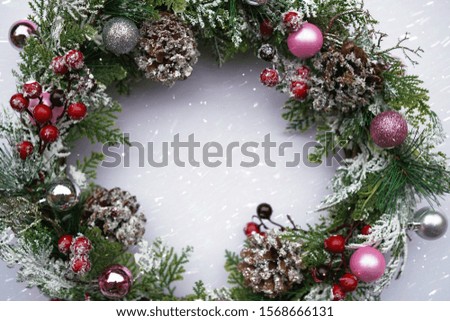 Cristmas wreath under snowflakes. Winter background