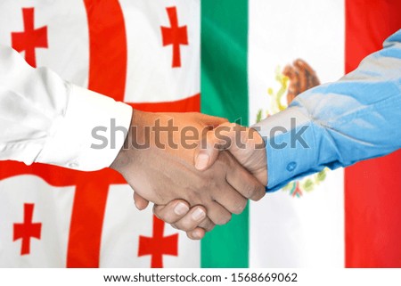 Business handshake on the background of two flags. Men handshake on the background of the Georgia and Mexico flag. Support concept
