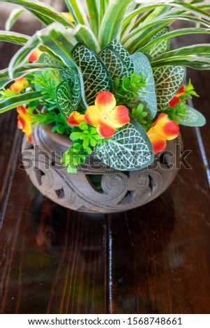 A bouquet of artificial flowers in a pot on the table. The decor of the interior. Comfort in home. Flowers in a pot. Beautiful flowers