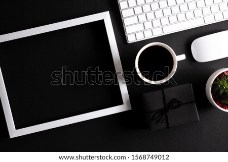White picture frame with keyboard mouse coffee cup, gift box and Christmas tree decoration on black background. Online Shopping concept and black Friday composition.