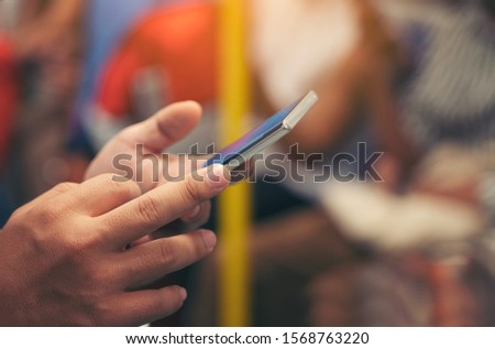 Close-up image of male hands using smartphone at night on city train, searching or social networks concept, hipster man typing an sms message to his friends 