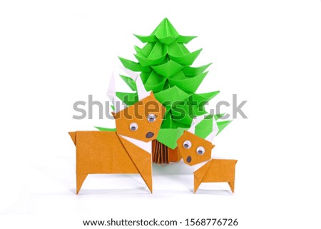 Origami paper art : Santa's reindeer and Christmas tree for greeting season of Christmas and New year. Copy space