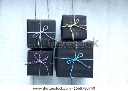 Hand craft black gift box with ribbon on white wood background.Top view.