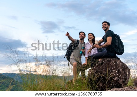 Group Of Friends Hiking Together through the Forest. They Talk Happy while hiking up the Mountains. Multiracial Young Adults Travel Hiking and Adventure in forest.