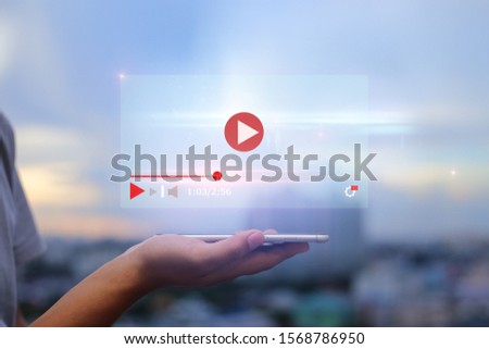 live video content online streaming marketing concept.Hands holding mobile phone on blurred urban city as background