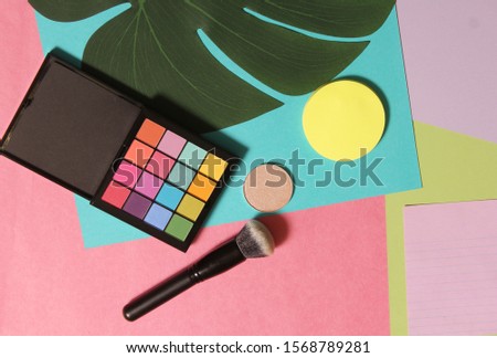 Cosmetics on Blank notebook pages with tropical leaf and brushes