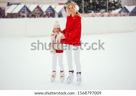 Family in a winter park. Mother with daughter in a ice arena