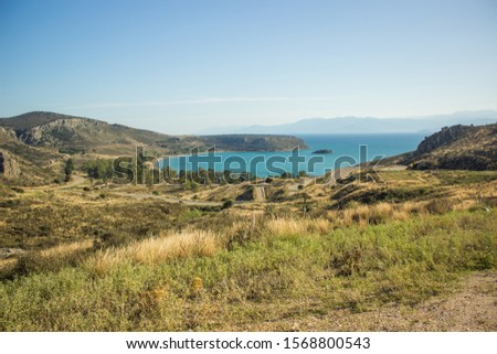 top view scenic landscape yellow rocky hills with curved car road to Mediterranean sea coast in Peloponnese half island in Greece  