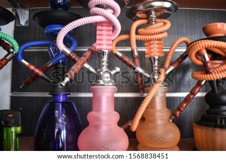 Hookahs. A hookah also known as a water pipe, narghile or qalyān is a instrument for smoking flavored tobacco in which the smoke is passed through a water basin, often glass based, before inhalation.