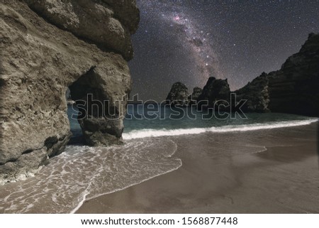 Rocky beach at  midnight, Lagos, Portugal.   Beautiful galaxy above the rocks. vintage style picture Elements of this image furnished by NASA