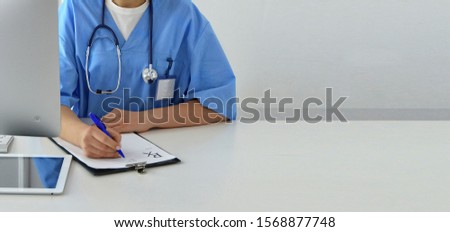 Doctor writes a prescription. Medicine. Office desk with tablet, prescription, X-Ray. Practitioner with a stethoscope. Conceptual image.  Copy space for your text.
