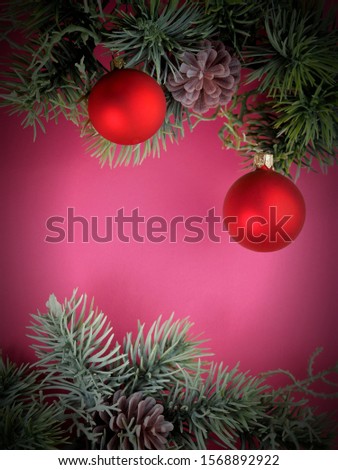 New Year picture. Spruce branch with Christmas toys on a red background.