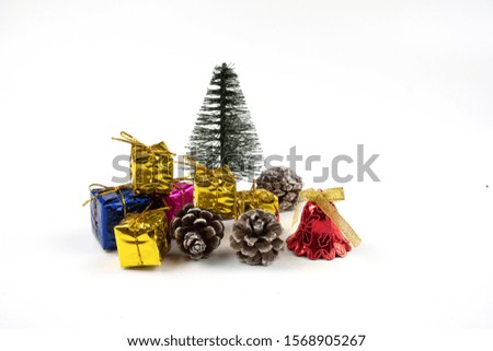 colorful gift present box for christmas and new year with christmas tree behind decorated with pine cone