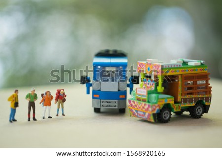 Miniature people : Traveller backpacker standing with Thai farming trucks and Thai style taxi. Travel and Adventure concepts in Thailand