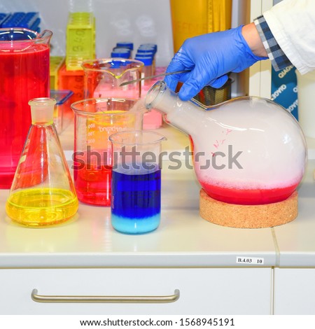 Pouring of white smoke out of a flask  with red solution (Demonstration experiment in a chemical  laboratory