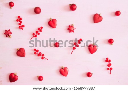 Pink wooden christmas background with red christmas decorations. View from above