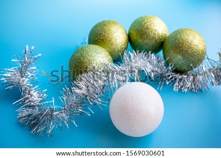 Christmas tree decorations with tinsel and garland on blue background for Christmas.