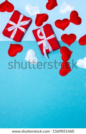 Background and blank for congratulations on Valentine's Day from hearts and gifts on a blue background. Place for inscription and congratulations on Valentine's Day. Vertical top view, flat lay.