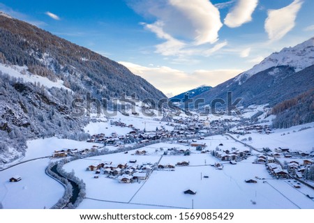 Winter morning cityscape in the Austrian town of Neustift. Aerial view of the alps mountains valley. Tyrol, Stubai