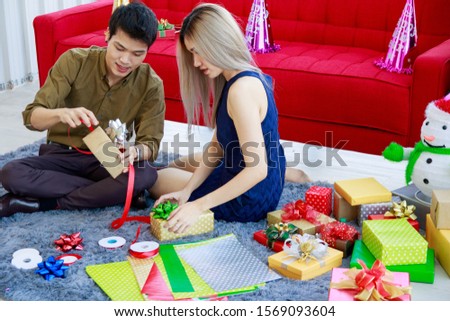 Young Asian Couples Wrapping gift For Christmas and New Year. Fun mood