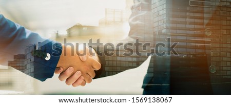 Close up of a business people with a handshake Agreements to do business together show trust and confidence in the investment in real estate. copy space of banner Royalty-Free Stock Photo #1569138067