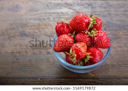fresh strawberries in a plate on a brown wooden background. place for text