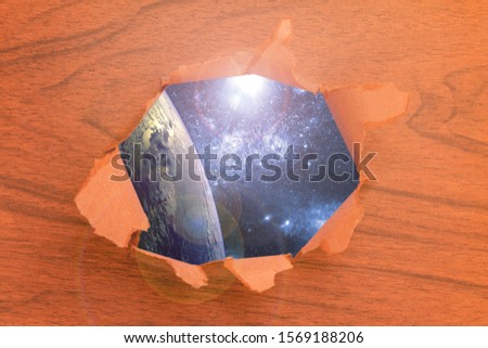 a torn piece of paper with a hole with the universe galaxy background inside, elements of this image furnished by nasa