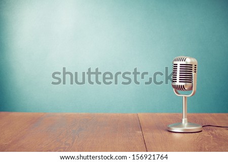 Retro style microphone on table in front aquamarine wall background Royalty-Free Stock Photo #156921764