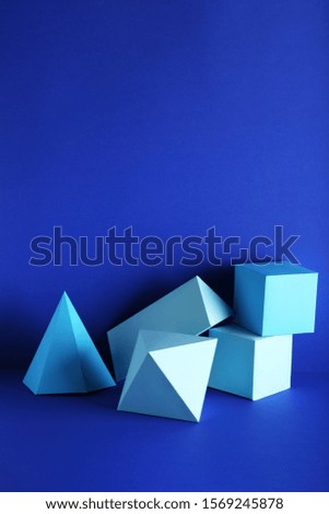 Paper geometric figures on blue background
