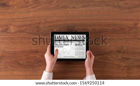 Hand with tablet reading news on tablet
