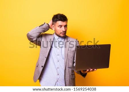 Portrait man forget or problems confused with laptop software isolated on yellow background.