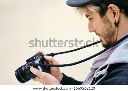 Hipster Street Photographer Reviewing Pictures On Mirrorless Camera Display
