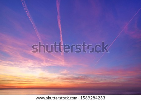 Bewitching magical gradient sky with plane traces after sunset