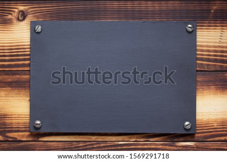 nameplate or wall sign at  wooden background texture surface, with screws