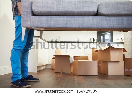 Close Up Of Man Carrying Sofa As He Moves Into New Home Royalty-Free Stock Photo #156929909
