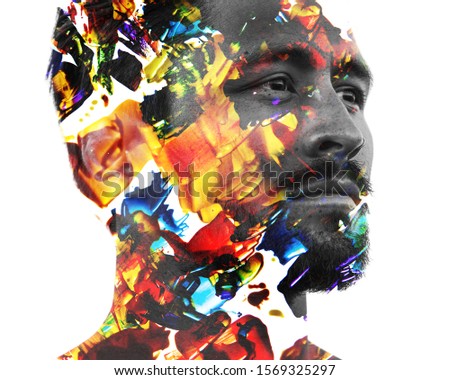 Paintography. Double exposure portrait of a man with strong features combined with handmade painting of colorful brushstrokes which dissolve into his skin