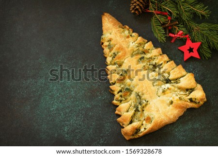 Christmas snack menu. Pizza Christmas tree with mozzarella and spinach on a dark tabletop background. Copy space.