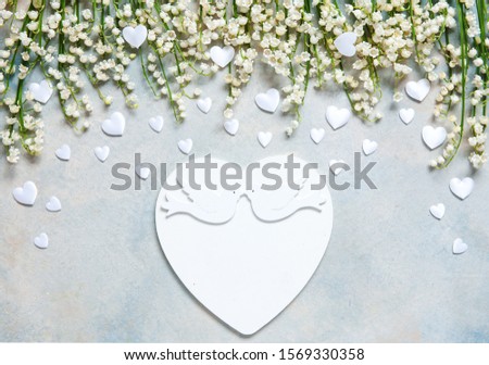  Pattern of lily of the valley flowers and white atlas hearts on a blue sky background. Concept for Valentine's Day and other spring holidays. Greeting card, wedding or engagement  invitation 