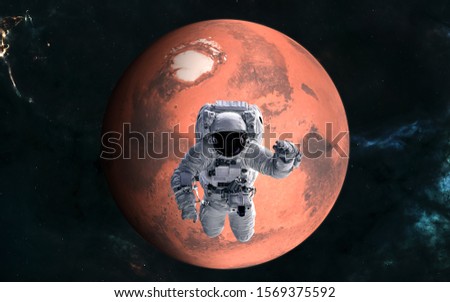 Mars. Astronaut in front of the red planet of the solar system. Science fiction. Elements of this image furnished by NASA